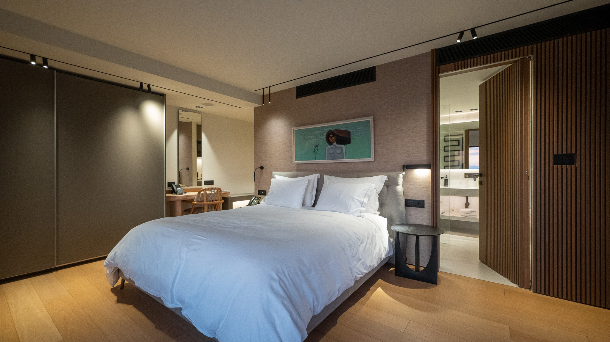 Dusit Suites Athens, suite bedroom with king bed and framed teal artwork