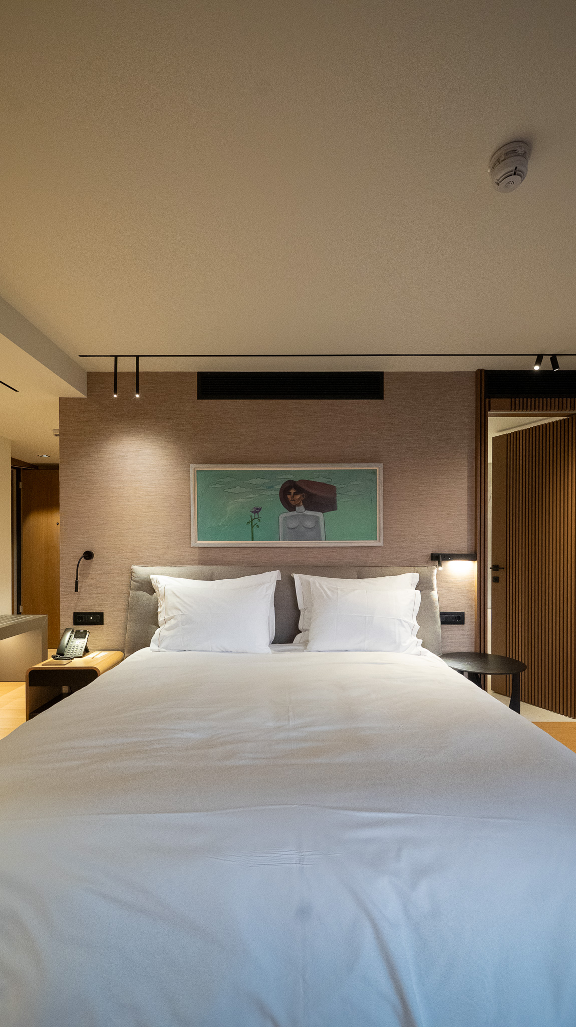 Dusit Suites Athens, symmetrical bedroom vignette with framed portrait artwork