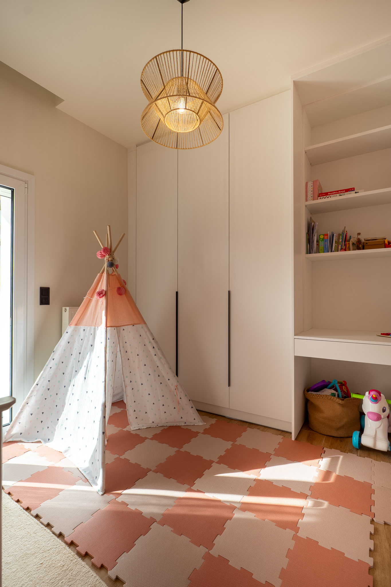 A&K Chorothetisis, playroom with rattan pendant, white wardrobe and teepee on pink mat