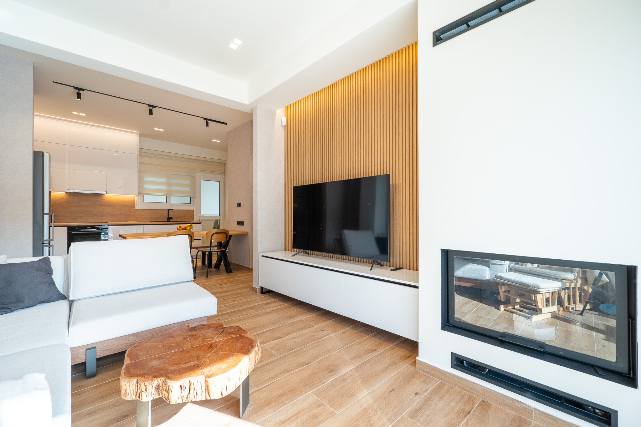 A&K Chorothetisis, living room reverse view with double-sided fireplace and oak slat feature wall