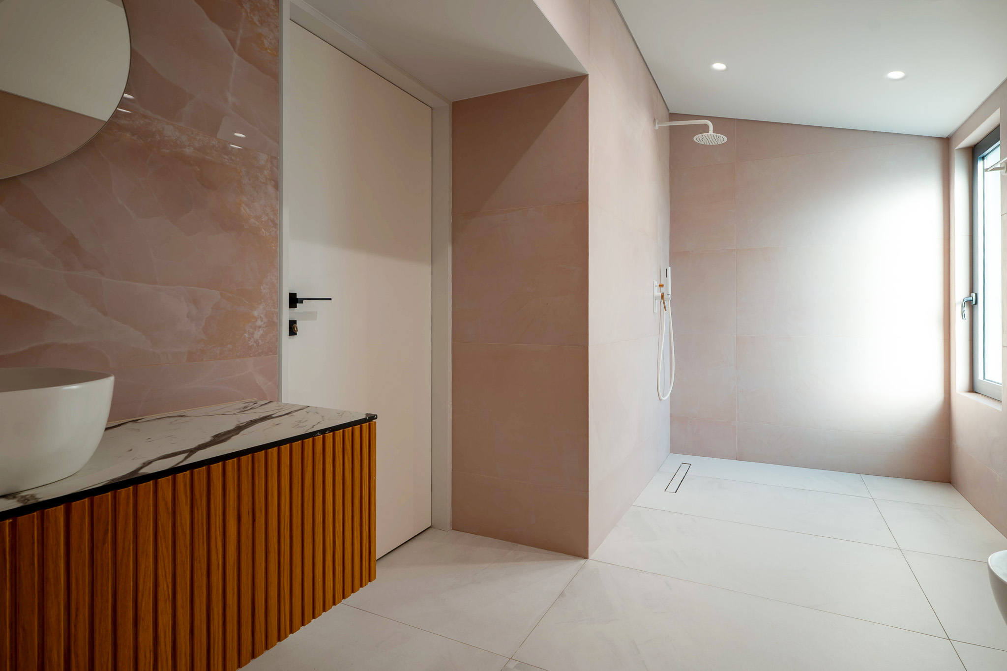 Villa Bond, pink onyx bath with wood-slat vanity