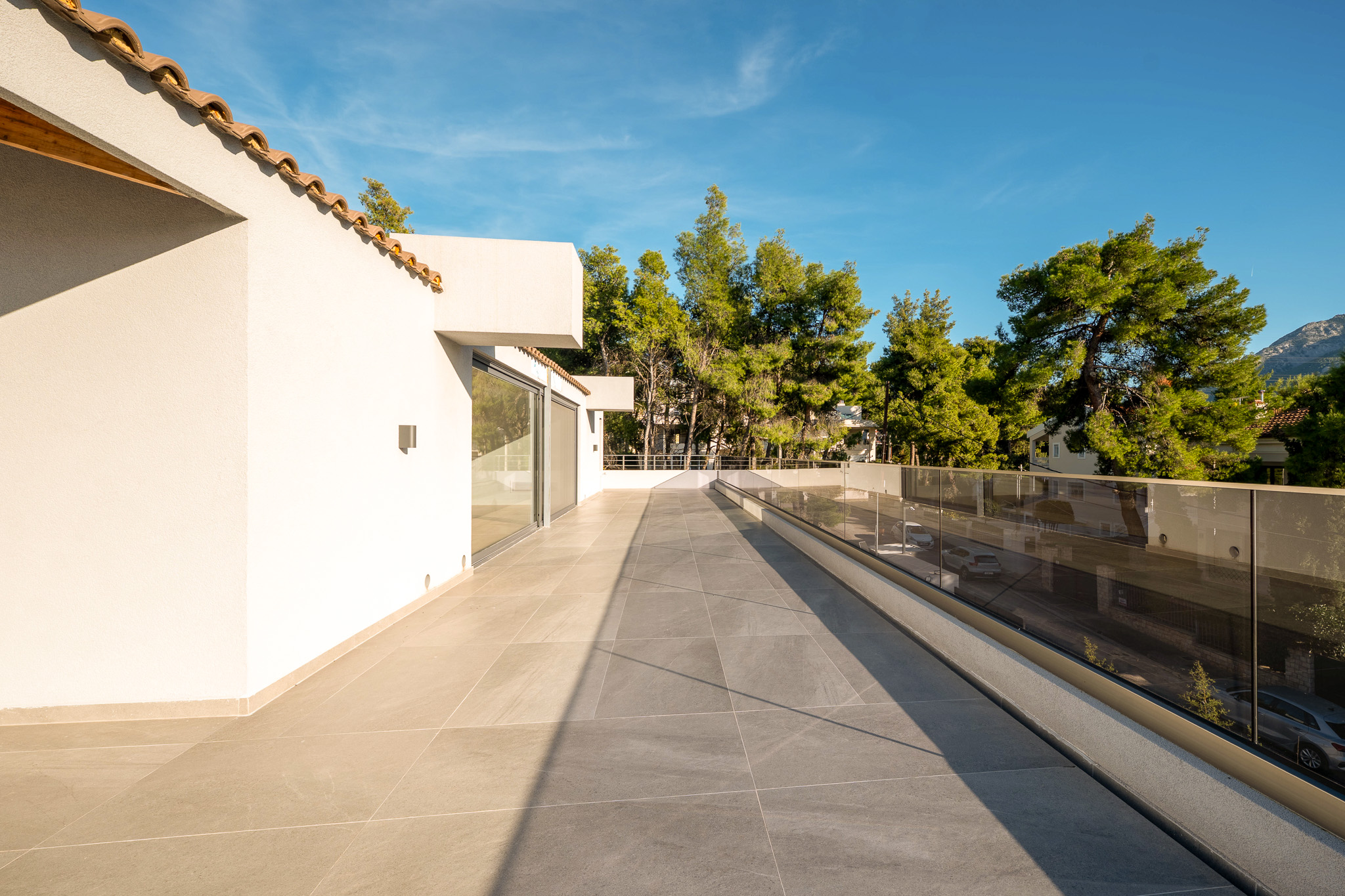 Villa Bond, upper-floor wraparound terrace with glass balustrade, viewed from above the canopy