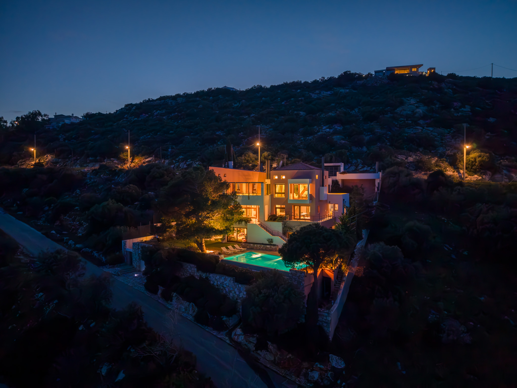 Villa Selene, twilight aerial of the lit residence